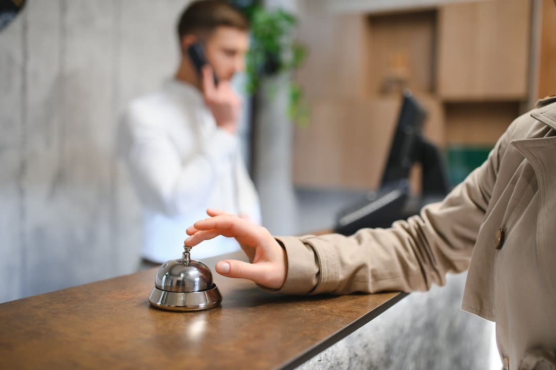 Hand of a woman using a hotel bell